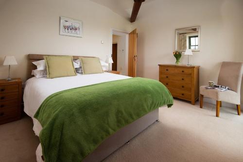 a bedroom with a large bed with a green blanket at East Lodge, Yorkshire in Bedale