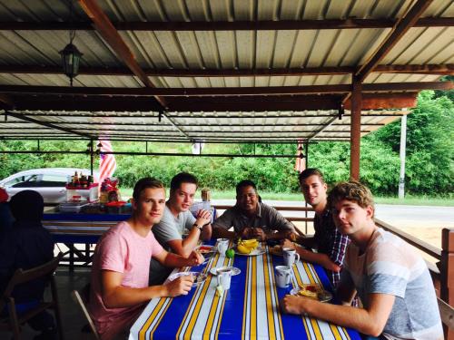 een groep mannen aan een tafel bij Dtahan Motel Taman Negara in Kuala Tahan