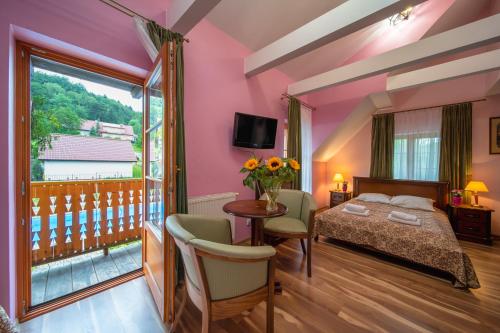 1 dormitorio con 1 cama y balcón en Hotel Modrzewiówka en Lanckorona