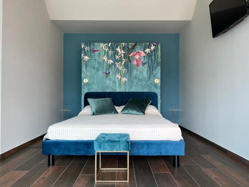 a bedroom with a bed with a blue headboard at Le Finestre Sul Lago in Cesenatico
