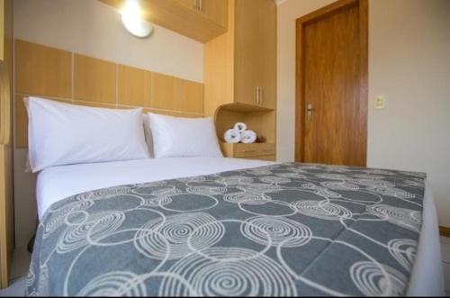 una camera da letto con un grande letto con una coperta blu e bianca di Flat Multiparque Sudoeste a Brasilia