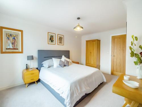 sypialnia z dużym białym łóżkiem i biurkiem w obiekcie Chestnut House w mieście Bridgend