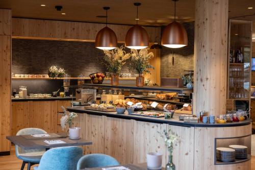 a restaurant with a counter with food on it at Hotel Garni Chesa Mulin in Pontresina