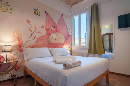 Umbrian Concierge - Villa Imbriani في بيروجيا: غرفة نوم بسرير مع جدار مزهر