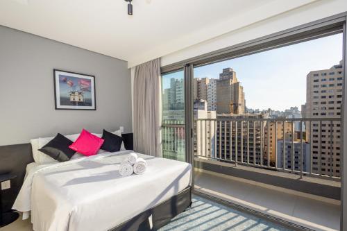 um quarto com uma cama e uma grande janela em 360 Suítes VN Consolação by Housi - Apartamentos mobiliados em São Paulo