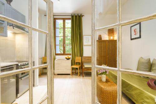 une cuisine avec une grande porte en verre menant à une pièce dans l'établissement LA MAISON VERTE SETE, à Sète