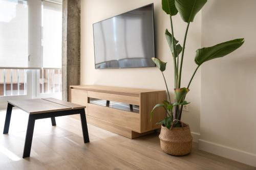 a living room with a potted plant and a table at Victoria's Home modern and cosy 2 bedroom apartment in Málaga