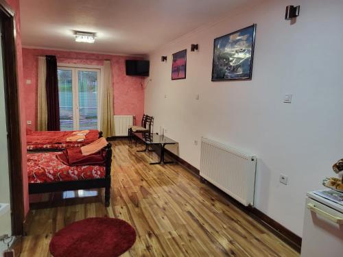 ein Wohnzimmer mit einem Bett und einem Tisch in der Unterkunft Miselin Apartmani in Vladičin Han