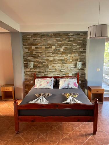 a large bed in a room with a brick wall at Apartments Sunpoint in Ulcinj