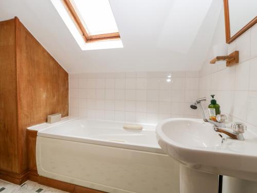 La salle de bains est pourvue d'une baignoire et d'un lavabo. dans l'établissement Redstart Cottage, à Leominster