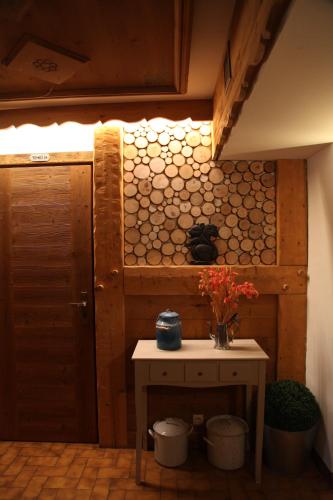 una habitación con una mesa y una pared de troncos en Le Cro-Bidou, en Bernex