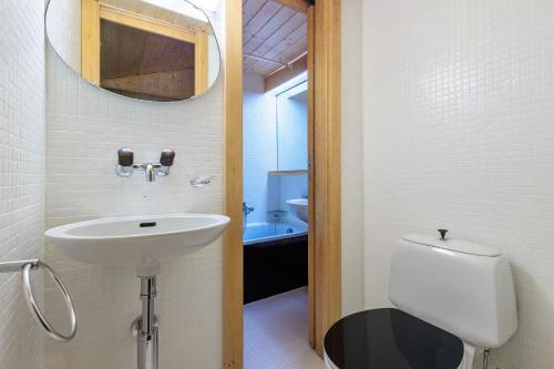 a bathroom with a sink and a toilet and a mirror at Superbe appartement, en 2 parties, au centre d'Anzère in Ayent