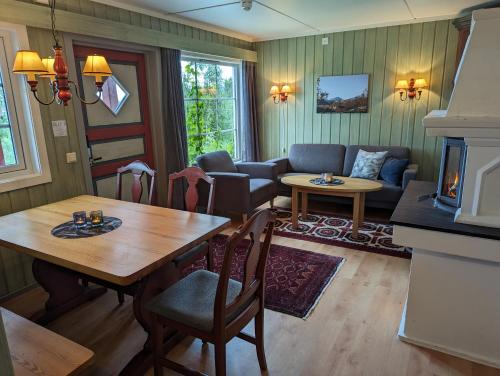 sala de estar con mesa y sofá en Grønolen Fjellgard, en Beitostølen