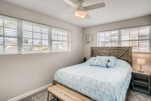 a bedroom with a bed and two windows at Cresting Wave Cottage by the Sea in Ormond Beach