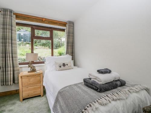 een slaapkamer met een bed met witte lakens en een raam bij Field Fare in Leominster