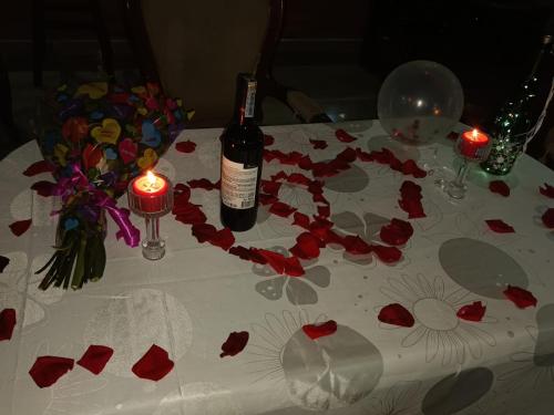 a table with a bottle of wine and flowers on it at Finca Hotel el Vergel Filandia Quindio in Filandia