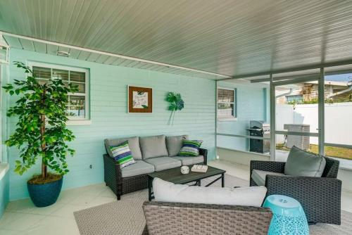 a patio with a couch and chairs and a table at Cresting Wave Cottage by the Sea in Ormond Beach
