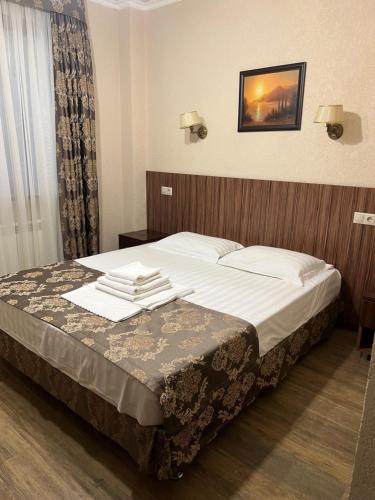 ein Bett in einem Hotelzimmer mit Handtüchern darauf in der Unterkunft Guest House Ritsa in Gagra