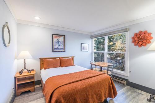 a bedroom with a bed and a window at Mountainside Inn 103 by Alpine Lodging Telluride in Telluride