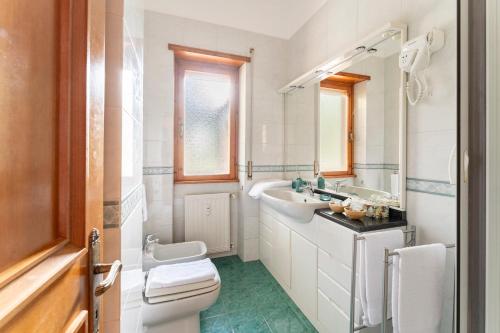 uma casa de banho branca com um lavatório e um WC em EASHOME EUR Mostacciano Bilocale adiacente IFO em Mostacciano