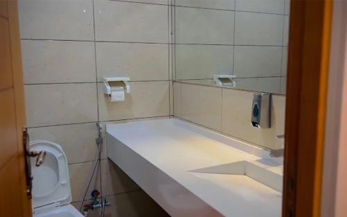 La salle de bains est pourvue de toilettes, d'un lavabo et d'un miroir. dans l'établissement Rawaz Hotel & Motel, à Sulaymaniyah