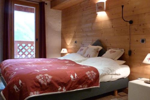 - une chambre avec un lit et un mur en bois dans l'établissement Les 4 saisons - luxury 3-bed apt with sauna, à Sainte-Foy-Tarentaise
