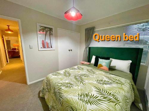 1 dormitorio con 1 cama con cabezal verde en Aucktons house en Auckland