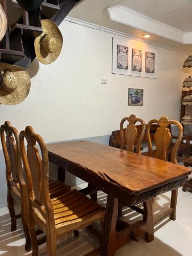 uma sala de jantar com uma mesa de madeira e cadeiras em Montana-Alpas Homestay em Santa Ana
