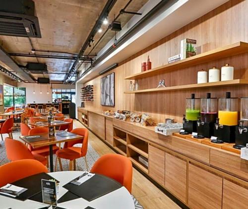 a restaurant with orange chairs and tables in a room at Hotel Executive Jardins in Sao Paulo