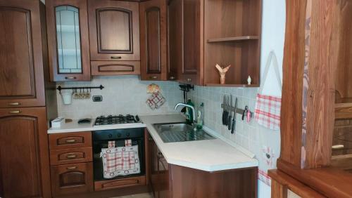 a kitchen with wooden cabinets and a stove top oven at Mansarda Monte Bianco in La Salle