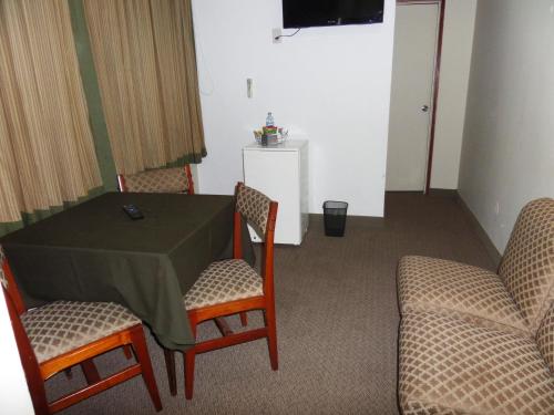 a room with a table and chairs and a television at Intiotel Chiclayo in Chiclayo