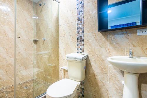 łazienka z toaletą, umywalką i telewizorem w obiekcie Hotel Cuchara de Palo Ayenda w mieście Santa Marta