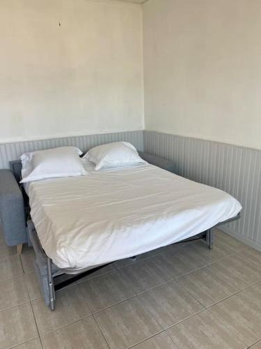 a bed in a room with two pillows on it at Studio plein centre ville in Propriano
