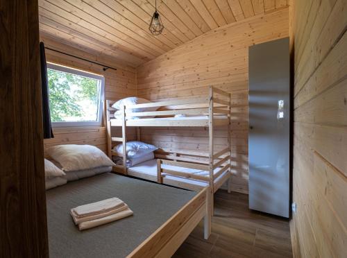 a room with bunk beds in a wooden cabin at Osada Lubniewice - Domki letniskowe nad samym jeziorem na wynajem 2-8osób in Lubniewice