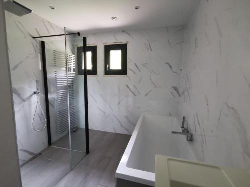 La salle de bains blanche est pourvue d'une baignoire et d'un lavabo. dans l'établissement La Rive du Doubs - 2 chambres - 5 Pers - 56, Chemin du Canal Du Rhône au Rhin, à Dole