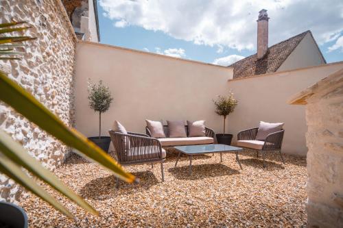 a patio with chairs and a table and a building at Appartement avec jardin privé - PACY SUR EURE in Pacy-sur-Eure