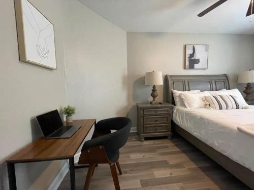 a bedroom with a bed and a desk with a laptop at Cozy Portsmouth Retreat 2BR 1BA in Portsmouth