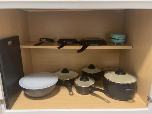 une cuisine avec des casseroles et des poêles sur une étagère dans l'établissement Cozy Portsmouth Retreat 2BR 1BA, à Portsmouth