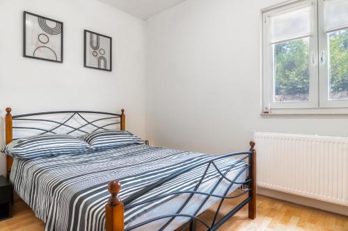 ein Schlafzimmer mit einem Bett und zwei Fenstern in der Unterkunft Villa Dalmatina 