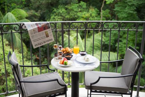 a table with a plate of food on a balcony at Palácio Tangará - an Oetker Collection Hotel in São Paulo