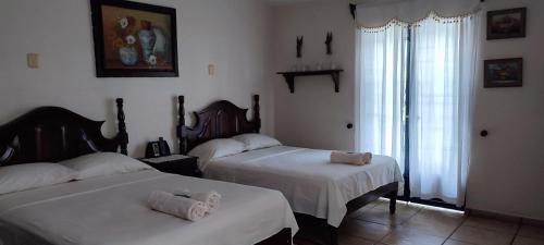 a bedroom with two beds with towels on them at Posada Bugambilias in Catemaco