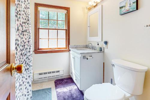a bathroom with a toilet and a sink and a window at Woodland Oasis in Rockport