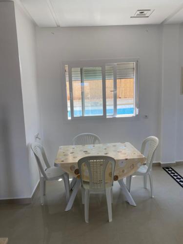 a dining room with a table and chairs and a window at Villa a 10 minutes de là plage in Ras El Ma