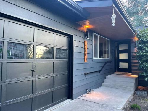 a house with a garage door and a staircase at Zen Haus Serene Retreat, prime location with views in Eugene