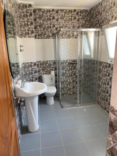 a bathroom with a shower and a sink and a toilet at Villa a 10 minutes de là plage in Ras El Ma