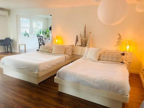 two beds sitting next to each other in a bedroom at Zen Haus Garden Retreat, prime location, Luxe amenities in Eugene