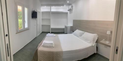 a bedroom with a large white bed and a window at Campeggio 2 Mari in Ovile la Marinella