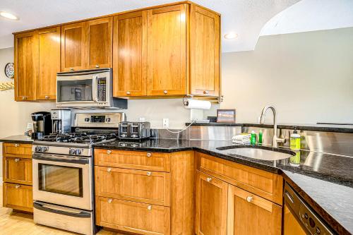 a kitchen with wooden cabinets and a stove top oven at Lake View Getaway in Saugatuck