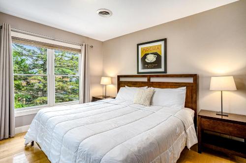 a bedroom with a large bed and a window at Lake View Getaway in Saugatuck