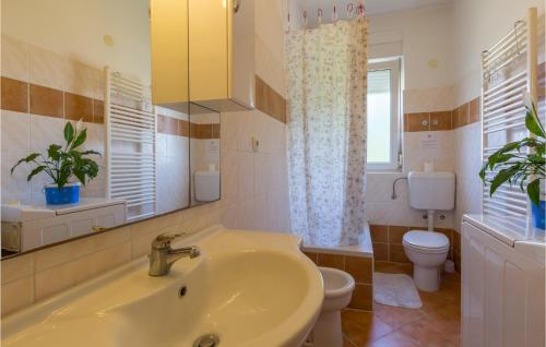 uma casa de banho com um lavatório e um WC em Stunning Apartment In Umag With 2 Bedrooms And Wifi em Umag